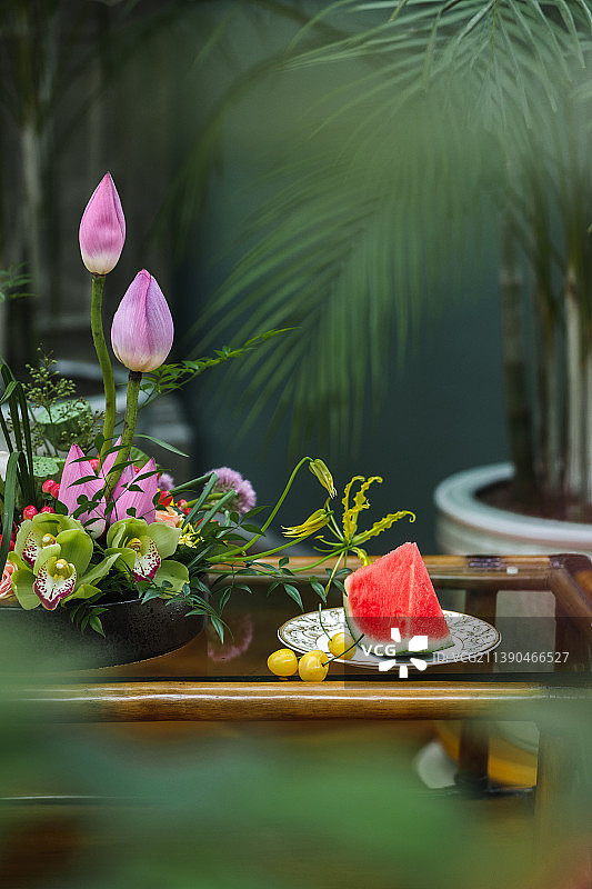 盛夏季節桌子上的荷花花藝和西瓜圖片素材