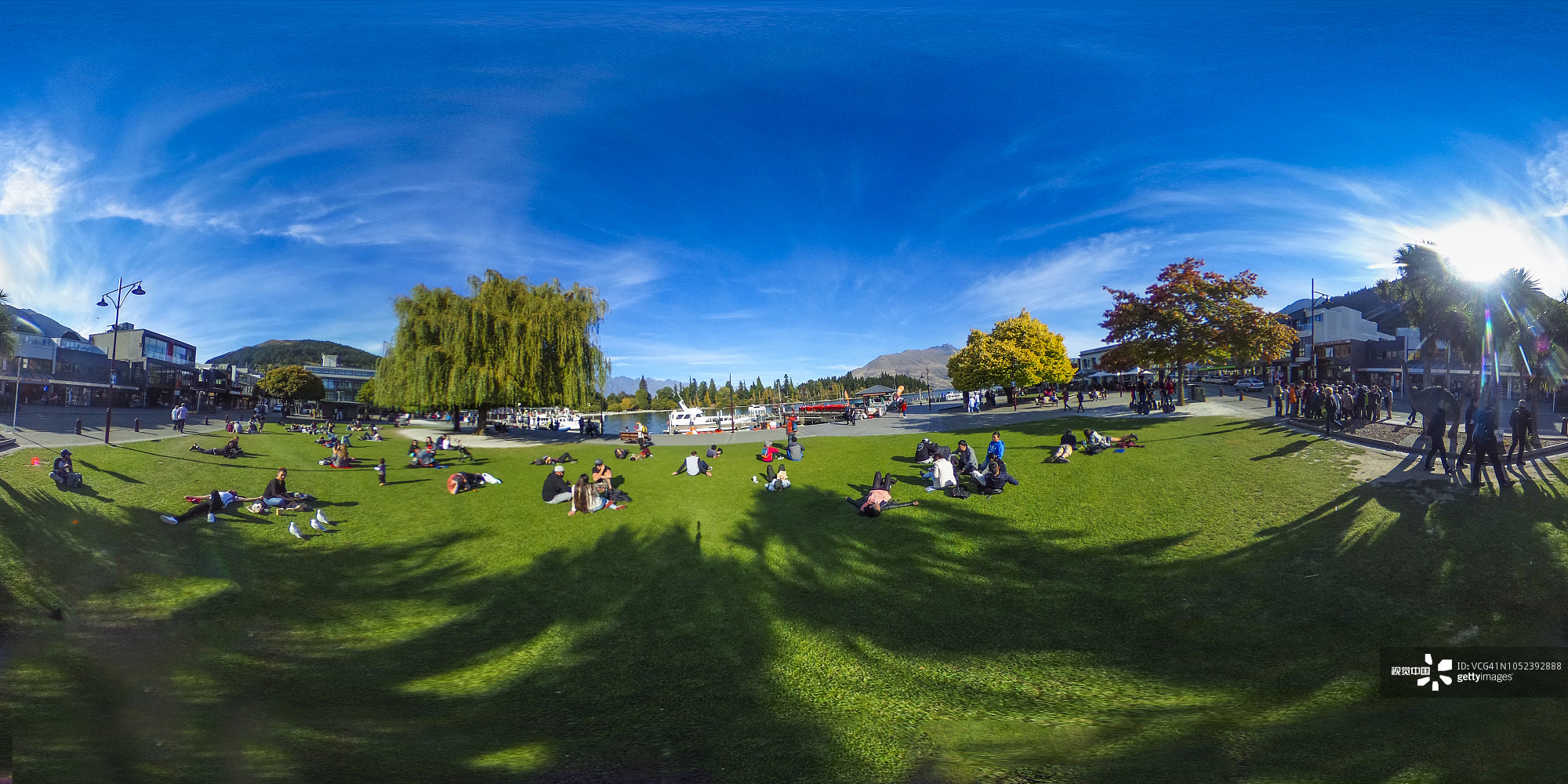 2017年4月，新西兰皇后镇。阳光明媚的下午，游客在瓦卡蒂普湖美丽的风景区放松身心。图片素材
