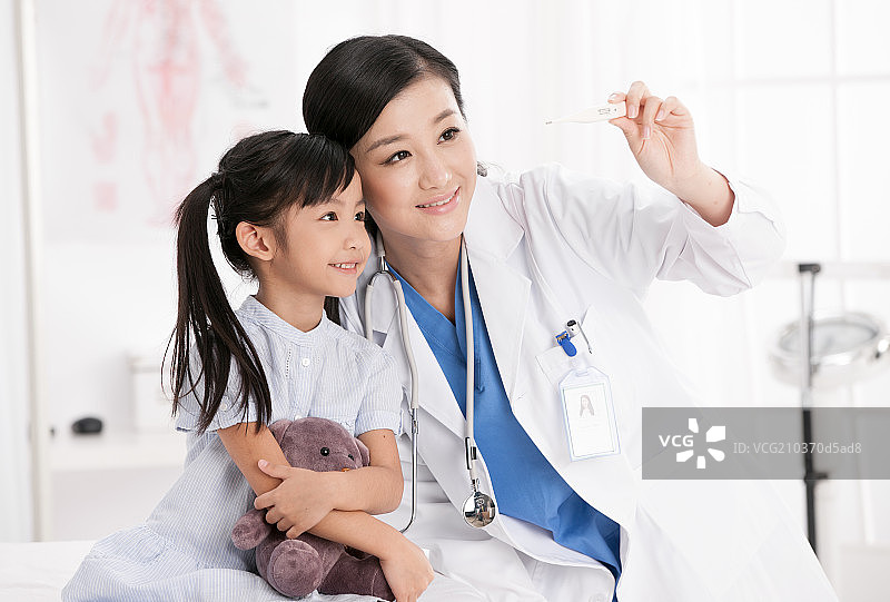 医生正在为女孩测量体温图片素材