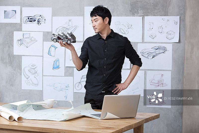 汽车设计师手拿汽车模型图片素材