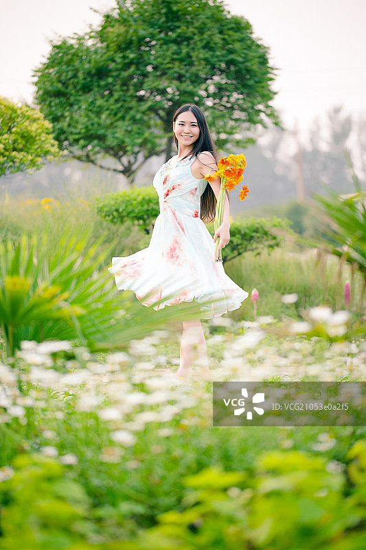 年轻美丽的中国女孩在花园里玩图片素材