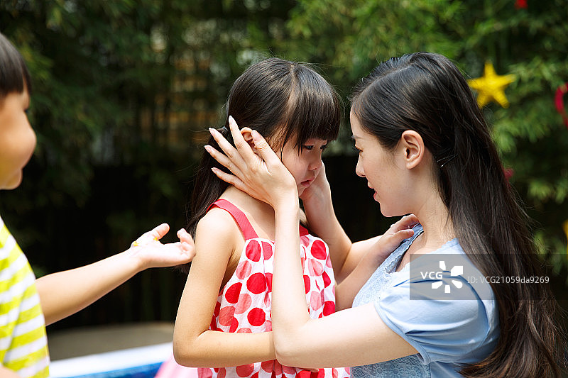 幼儿园里教师在安慰伤心的女孩图片素材