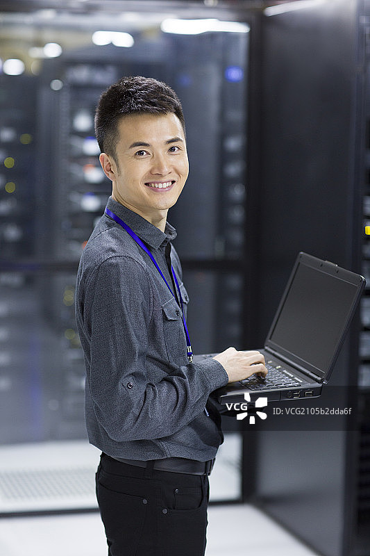 技术员在机房使用笔记本电脑图片素材