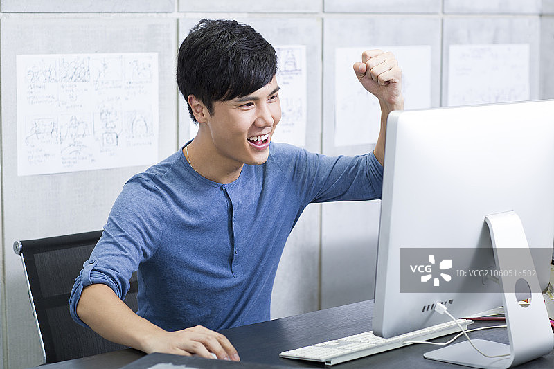 年轻男子在办公室庆祝图片素材