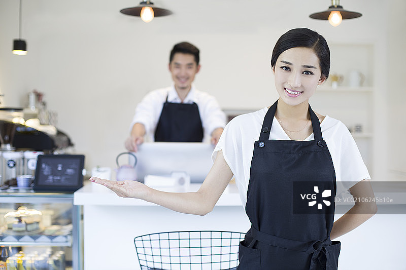 咖啡店女服务员做欢迎手势图片素材