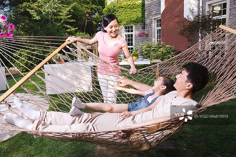 幸福的三口之家在花园里图片素材