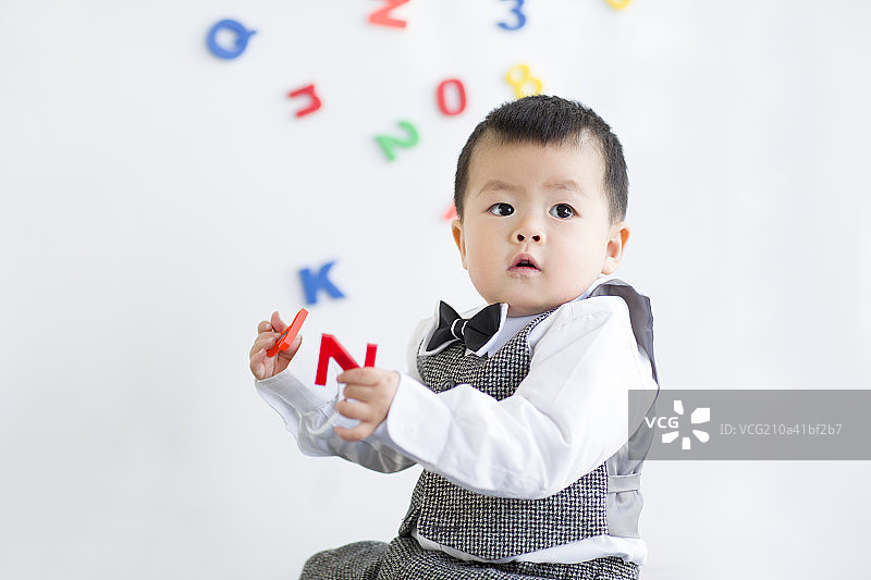 可爱的宝宝玩数字和字母玩具图片素材