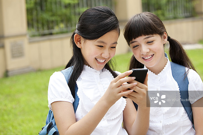 兴奋的小学生玩手机图片素材