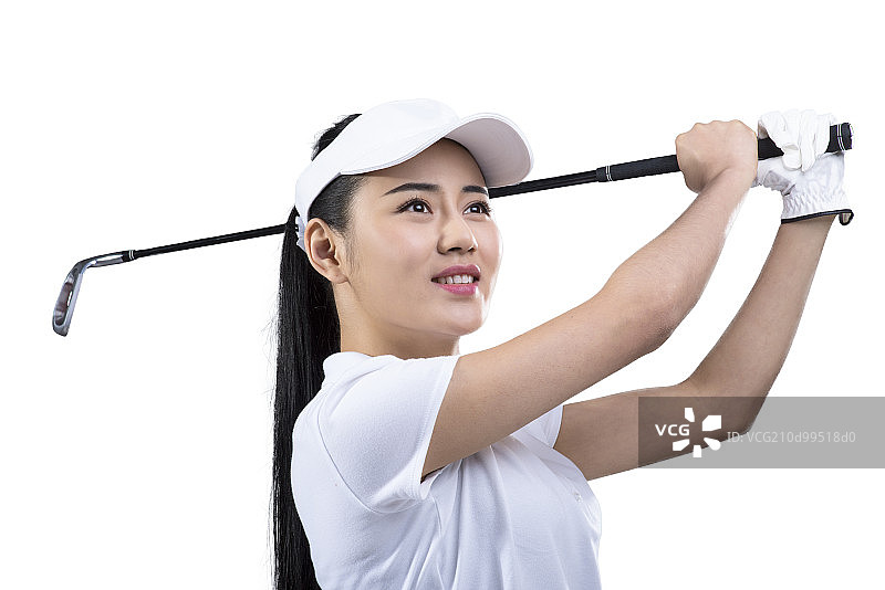 Young female golfer swinging golf club图片素材
