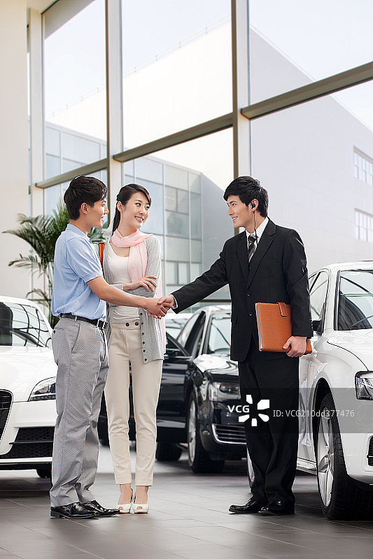 青年夫妇在4S点购买汽车图片素材