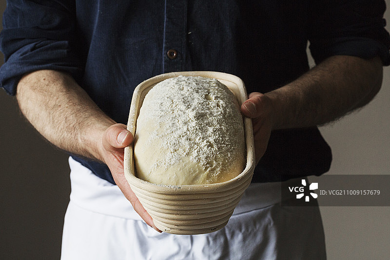 面包师手拿刚出炉的白面包特写图片素材