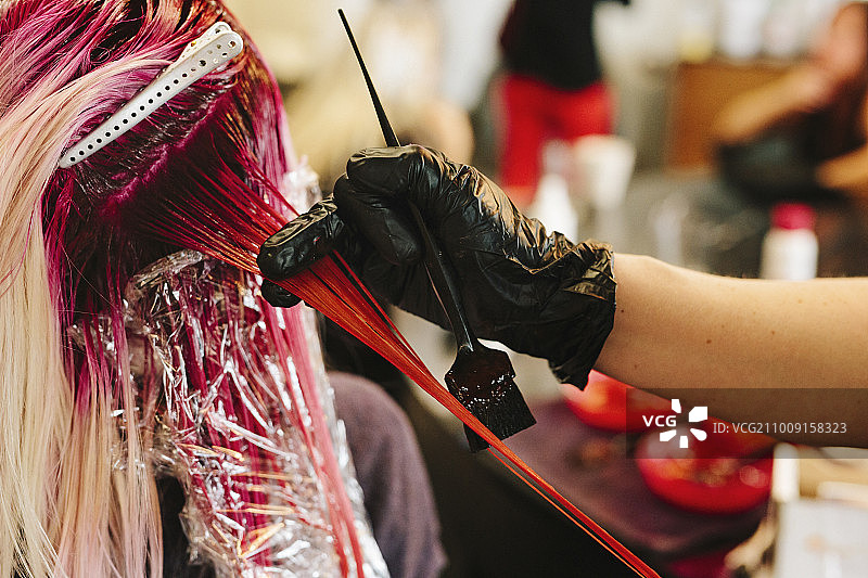 染发师为顾客的金色长发染粉色图片素材