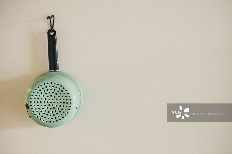 挂在墙上的搪瓷漏勺，复古厨房设备图片素材