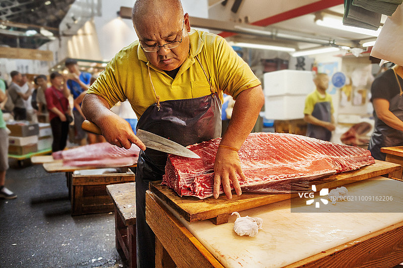 东京的传统鲜鱼市场：鱼贩正在分割大鱼图片素材