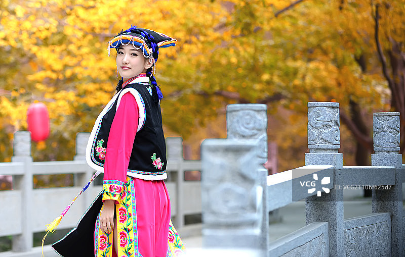 穿少数民族服装的美女站在石桥上图片素材