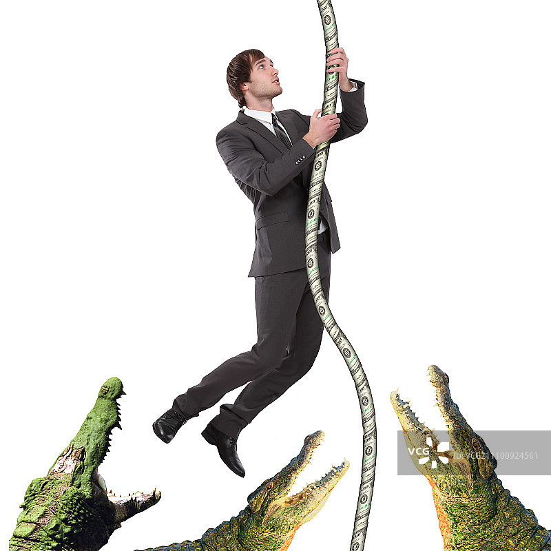 身穿黑色西装，攀爬绳索躲避鳄鱼的商人图片素材