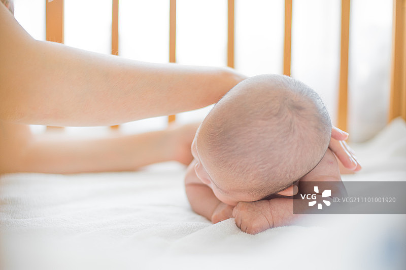 婴儿床上抚摸婴儿图片素材