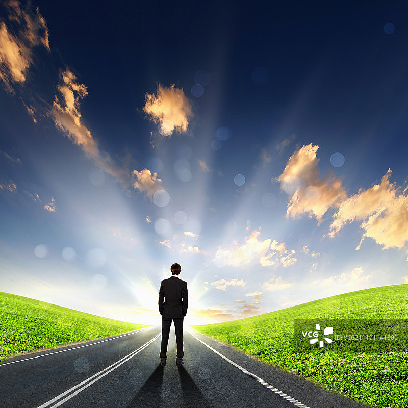 孤独的身影，通往地平线的空旷道路和多云的天空图片素材