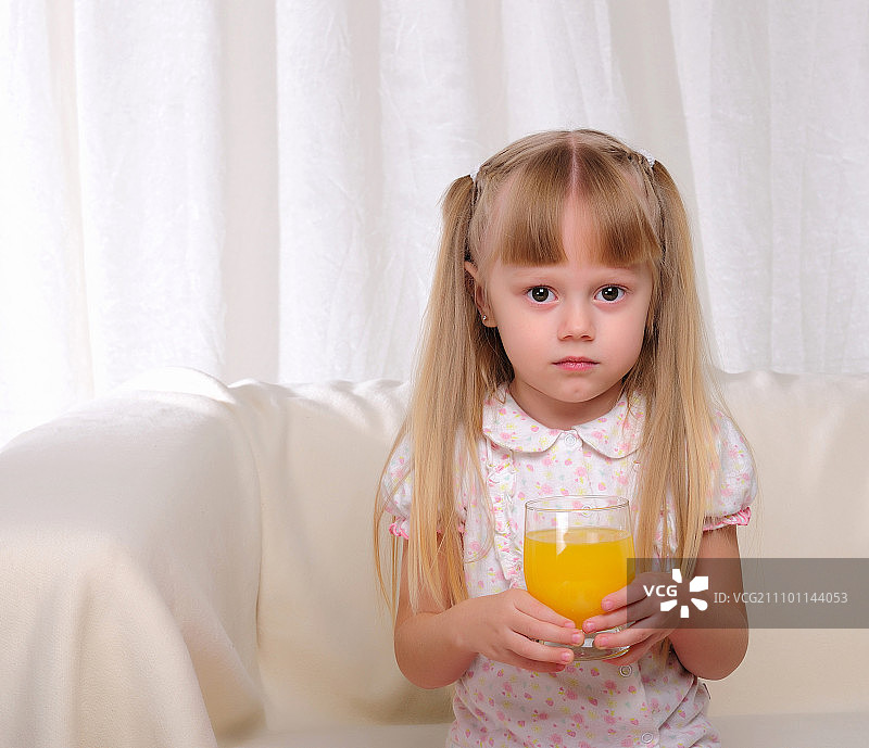 小女孩拿着一杯橙汁图片素材