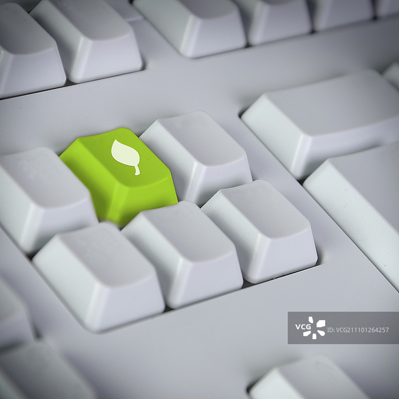 绿色科技概念：带有绿色回车键和回收标志的电脑键盘图片素材