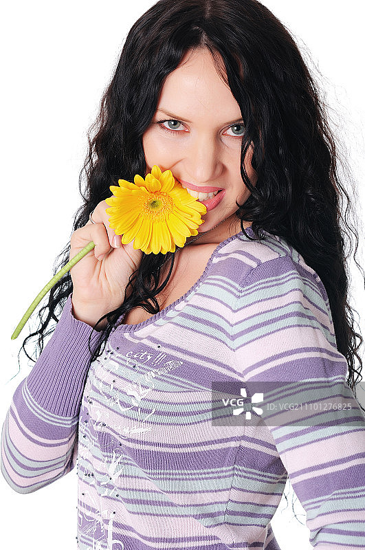 年轻漂亮的黑发女子玩弄黄色花朵，白色背景图片素材