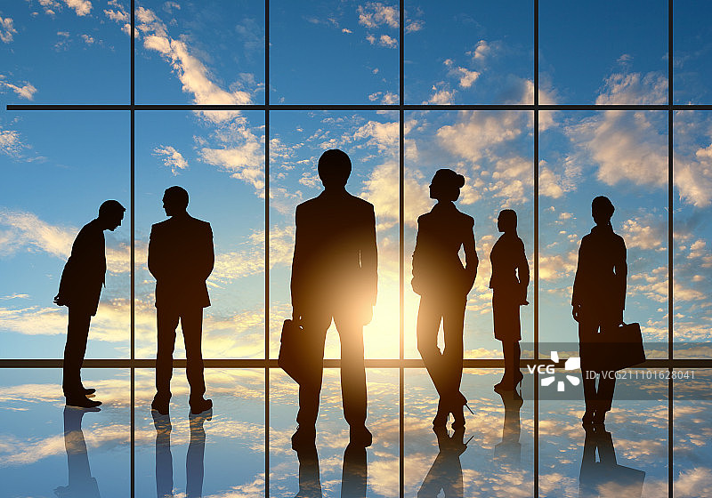 办公室会议：商务人士在全景办公室窗口前的剪影图片素材