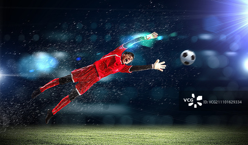 聚光灯下的体育场里，守门员接住了球图片素材