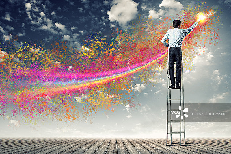 男人绘制泼溅图案，年轻人站在梯子上图片素材