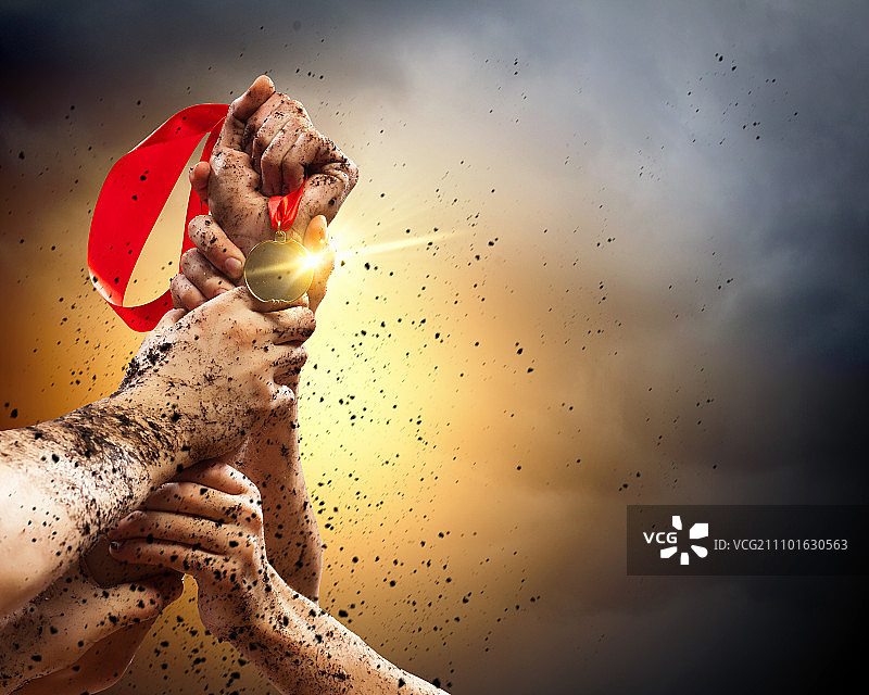 在黑暗暴风雨的天空下，手握紧奖牌图片素材