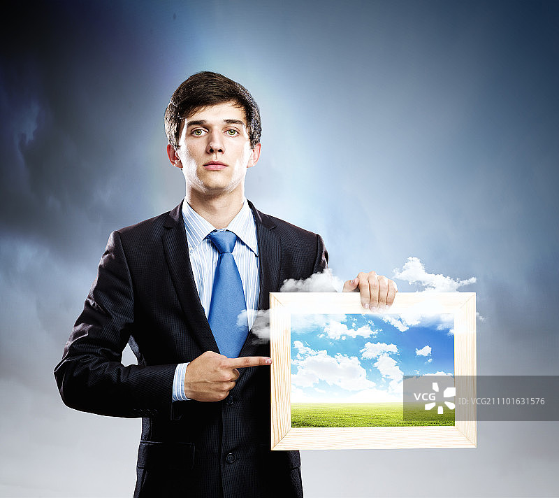 摄影概念：拿着相框的英俊男人图片素材