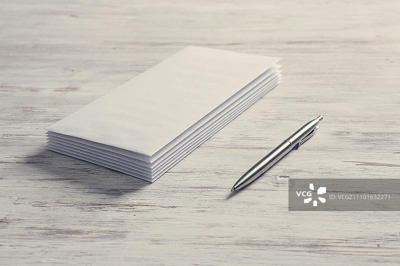 商务便签卡片：木质复古桌面上的空白白色卡片图片素材