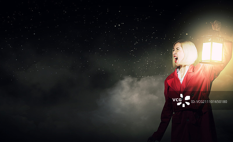 迷失的女人：红披风金发女子在黑暗中提着灯笼图片素材