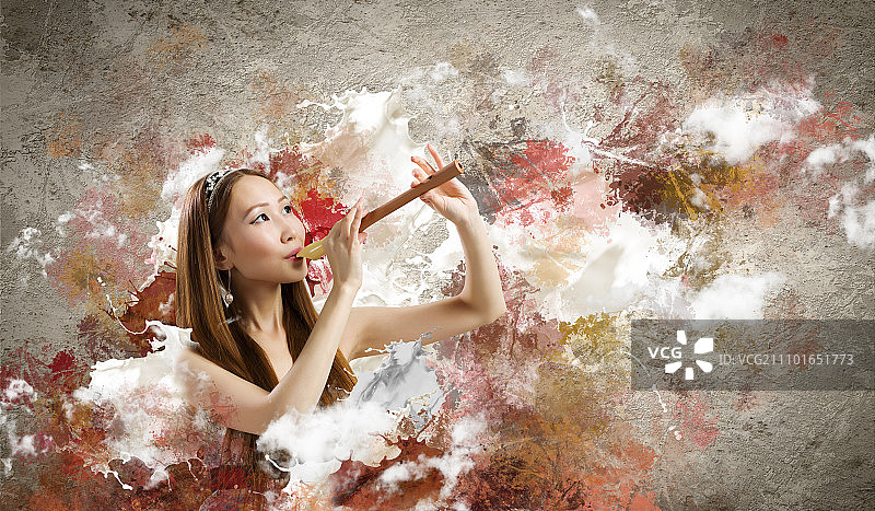 吹奏短笛的女人：年轻亚裔女性在彩色背景下演奏短笛图片素材