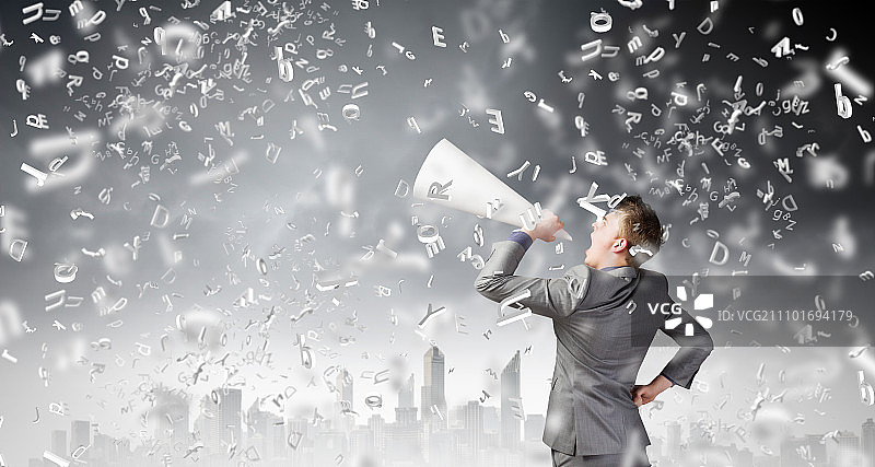 拿着小号的男人。年轻商人对着纸小号情绪激动地尖叫图片素材