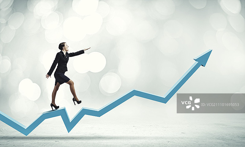 增长概念：快乐的女商人走在增长的图表上图片素材