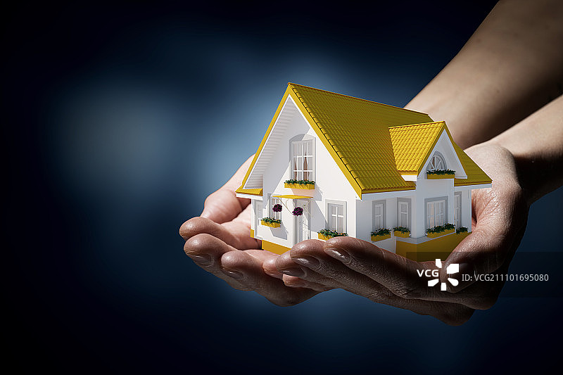 房地产概念：手捧梦想房屋模型图片素材