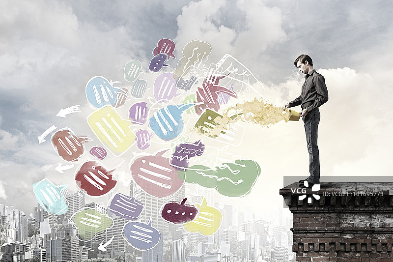 从桶里泼油漆的休闲装扮的年轻男人图片素材