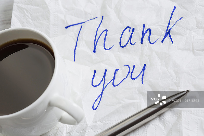 写在餐巾上的消息木桌上的餐巾和咖啡杯上的浪漫消息图片素材