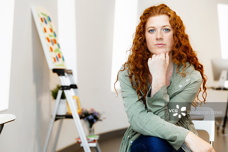 展示自己画作的年轻女艺术家，在画廊展示自己画作的年轻女艺术家图片素材