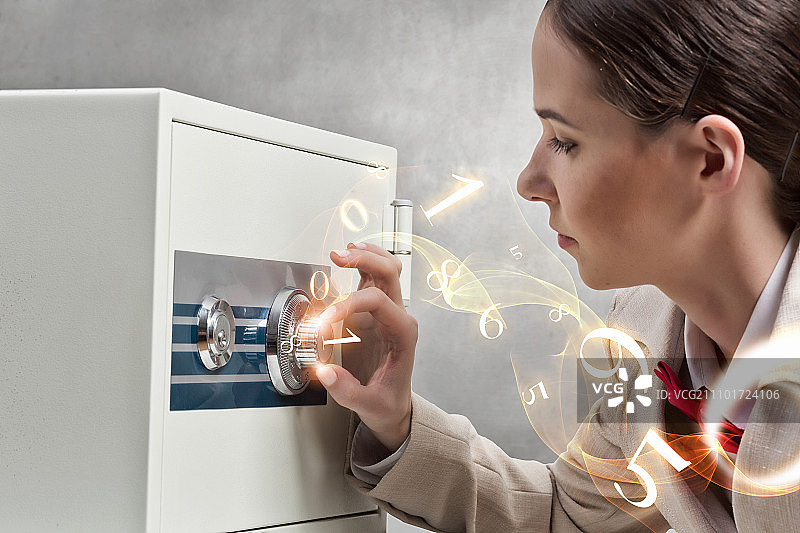 女人打开保险箱。年轻女商人输入密码打开保险箱图片素材