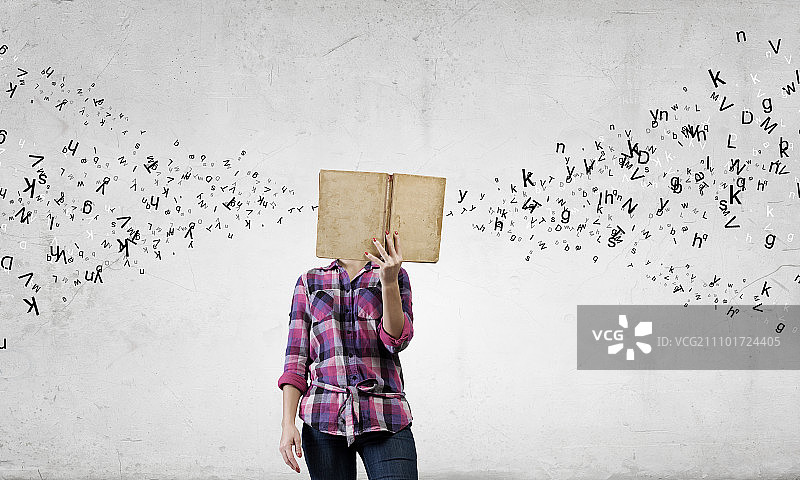 手捧书本的休闲年轻女人图片素材