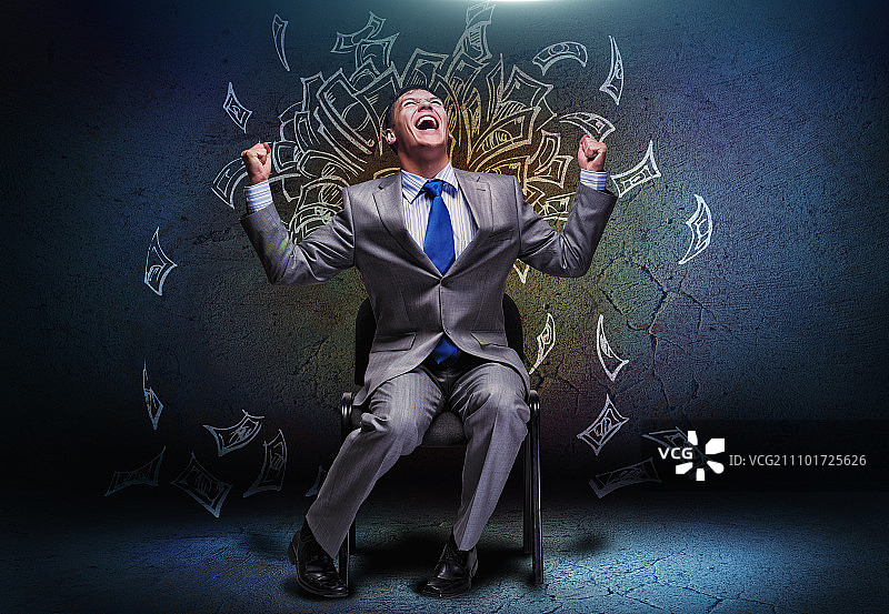 快乐的商人坐在钱雨下的椅子上图片素材