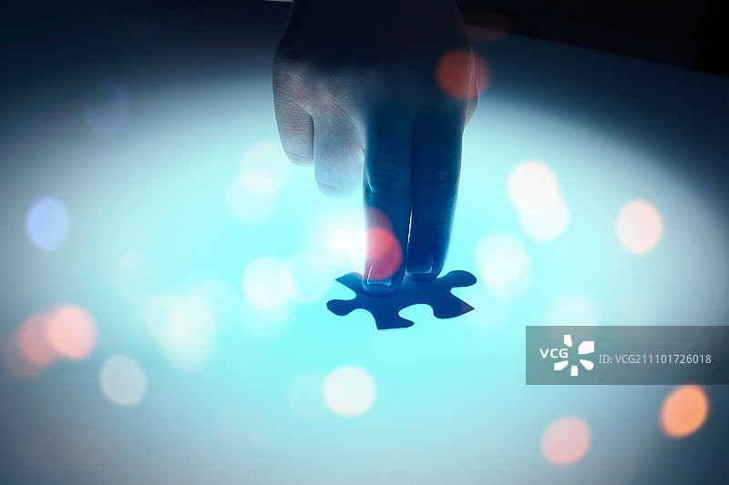 连接在一起：手部连接两块发光拼图图片素材