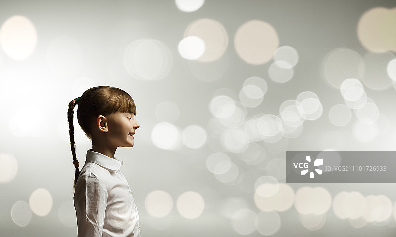 希望......在散景背景下闭着眼睛的女孩侧面图片素材