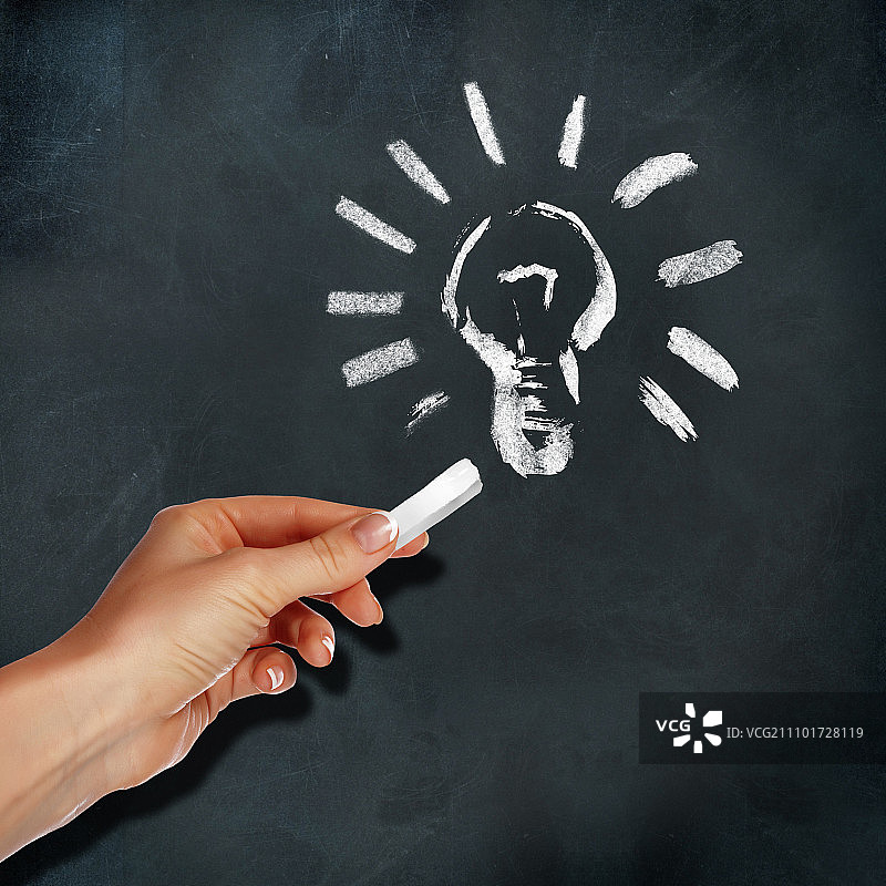 学校黑板和人手绘制的灯泡符号图片素材