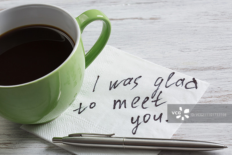 写在餐巾上的消息木桌上的餐巾和咖啡杯上的浪漫消息图片素材