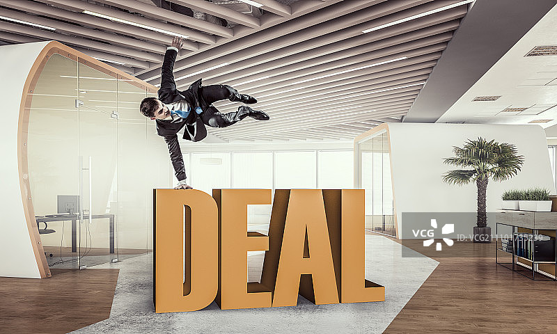 他达成了交易。年轻快乐的商人在办公室跳舞。混合媒体图片素材