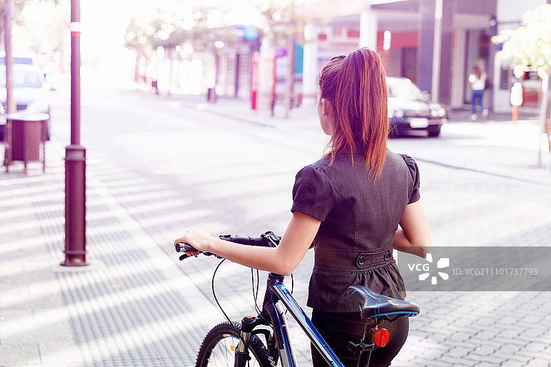 年轻女子骑自行车通勤图片素材