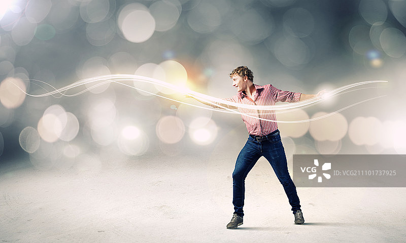 男魔术师：用魔法之光的年轻男子图片素材