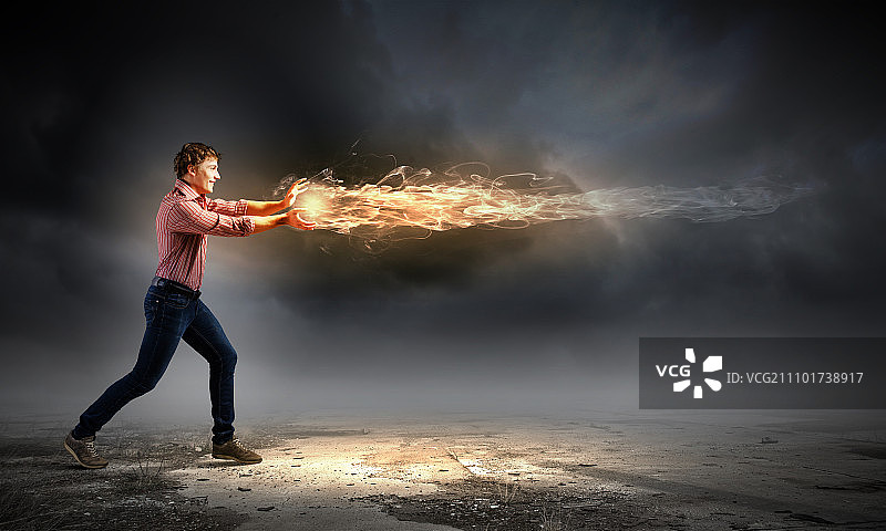 男魔术师。年轻人随意地扔着魔法火球图片素材